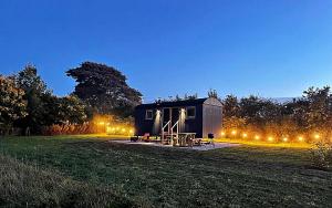 una casita negra en un campo por la noche en Luxury Shepherd Hut in the Peak District, en Bakewell