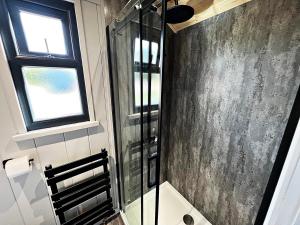 um chuveiro na casa de banho com uma cabina de duche envidraçada. em Luxury Shepherd Hut in the Peak District em Bakewell