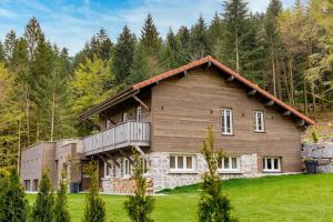 Cette grande maison en bois dispose d'un balcon sur un champ verdoyant. dans l'établissement Home des bois, à Ventron