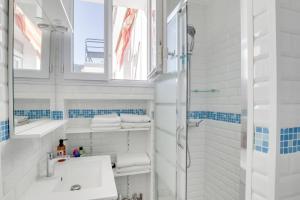 a white bathroom with a sink and a shower at Eiffel Tower view terrace Saint Germain des Pres in Paris +12 photos