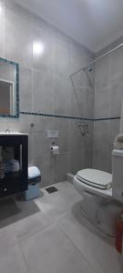 Un baño blanco con inodoro y lavabo. en Quincho 23 Cañuelas, en Cañuelas 11 fotos más
