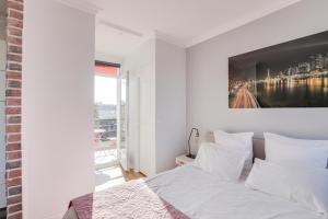 a bedroom with a white bed with a painting on the wall at Eiffel Tower view terrace Saint Germain des Pres in Paris
