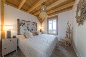 a bedroom with a white bed and a chair at Home des bois in Ventron