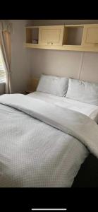 a bed with white sheets and pillows in a bedroom at S452 Golden Palm Resort in Chapel Saint Leonards