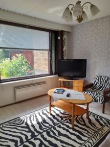 a living room with a tv and a coffee table at Laaksotie in Heinävesi