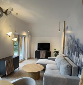 uma sala de estar com um sofá e uma mesa em Apartament Górska Osada 21 em Szklarska Poręba