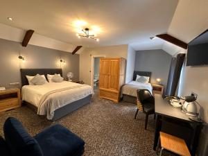 a hotel room with two beds and a desk at Spilman Hotel in Carmarthen