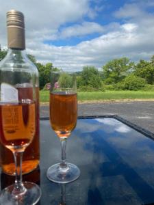 a bottle of alcohol and two wine glasses on a table at Corner Patch Retreat in Hoel-galed