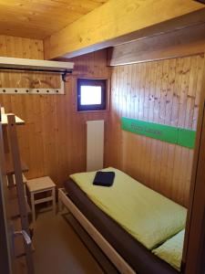 ein Schlafzimmer mit einem Bett in einer Holzhütte in der Unterkunft Alla Capanna in Verdasio