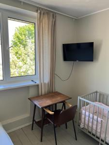 a room with a desk and a window and a crib at Topoliu 16 guesthouse in Šventoji
