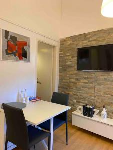 a room with a table and chairs and a television on a wall at MODERN APARTMENT IN THE HEART OF OLD TOWN in Rab