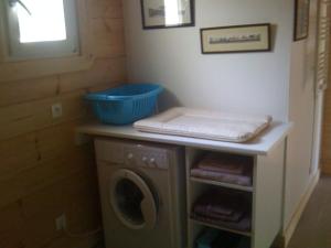 a laundry room with a washing machine and a blue bowl at Charmante maison en bois proche mer in Saint-Jean-de-la-Rivière