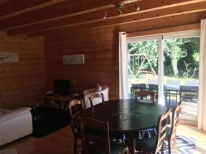 - une salle à manger avec une table et des chaises dans l'établissement Charmante maison en bois proche mer, à Saint-Jean-de-la-Rivière