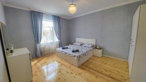a bedroom with a bed and a large window at Qafqaz Flower Villa in Gabala