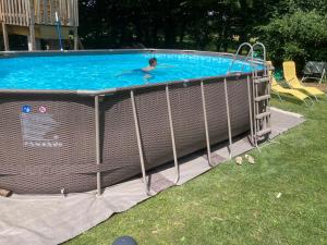 a man swimming in a swimming pool in a yard at La Parenthèse du Champion Gite 4 étoiles, 5 chambres, piscine, spa, sauna in Le Champion