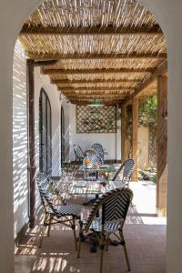 a patio with a table and chairs under a wooden ceiling at Giardini Penelope in Ciampino