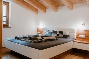 a bed in a room with white walls and wooden ceilings at Apart GuetGeanLossn in Längenfeld