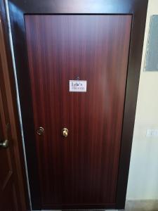 una porta di legno con un cartello sopra di Lela's room a Bari