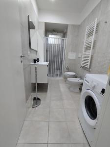 a bathroom with a washing machine and a toilet at Lela's room in Bari