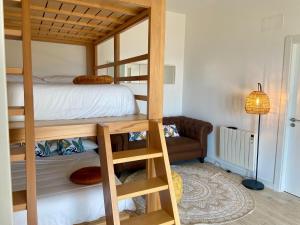 a bedroom with a bunk bed and a couch at Precioso loft en Caión ROCHA, sobre la arena y el mar in Cayón
