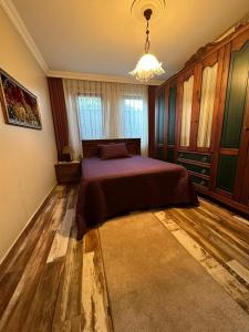 a bedroom with a bed and a chandelier at SİRİN VİLLA in Macka