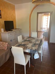 een eetkamer met een tafel en stoelen bij Appartamenti Budoni in Budoni