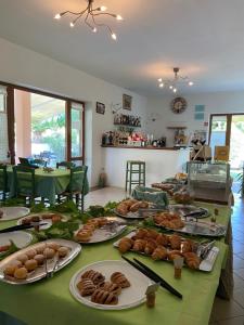 a table with plates of bread and pastries on it at Bed & Breakfast Alex in Porto Azzurro