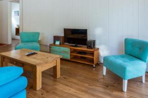 - un salon avec 2 chaises, une table et une télévision dans l'établissement BOG El Granero, à Villa La Angostura