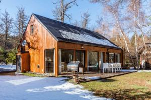 a wooden barn with a grill in the yard at BOG El Granero in Villa La Angostura