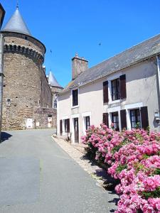 a street with pink flowers in front of a building at Charming detached 2 bedroom ancient house in medieval quarter of a small town in the Pays de la Loire, France in Sillé-le-Guillaume