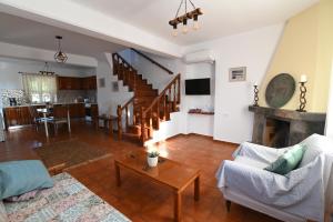 ein Wohnzimmer mit einem Sofa und einem Tisch in der Unterkunft Traditional Kos villa with swimming pool, lawn yard and bbq in Kos-Stadt