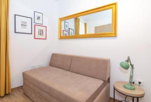 un sofá en una habitación con espejo y mesa en Casa Mia - Apartments & Suites, en Koper