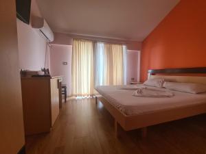 a bedroom with a bed and a large window at Hotel Kukesi in Pogradec