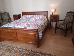 a bedroom with a bed and two chairs at Charming detached 2 bedroom ancient house in medieval quarter of a small town in the Pays de la Loire, France in Sillé-le-Guillaume