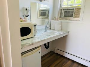 a kitchen counter with a microwave and a sink at Canadas Best Value Inn & Suites Summerside in Summerside +66 photos