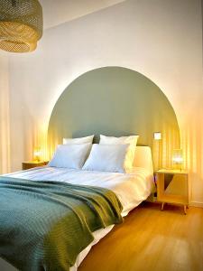 a bedroom with a large bed with an arch above it at Le Condorcet. Charme et confort à Championnet in Grenoble