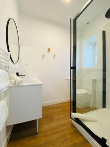 La salle de bains blanche est pourvue d'un lavabo et d'un miroir. dans l'établissement Le Condorcet. Charme et confort à Championnet, à Grenoble
