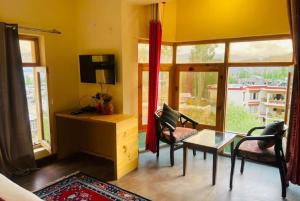 a living room with a tv and a table and chairs at Hotel DE Suzain-Leh in Leh +19 photos