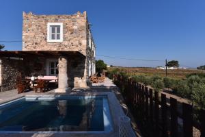 a house with a swimming pool next to a building at Traditional Kos villa with swimming pool, lawn yard and bbq in Kos