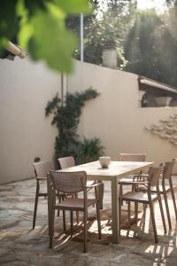 a wooden table and chairs and a table and a table and chairs at Villa Leveque - Kassiopi Hillside pool villa in Kassiopi