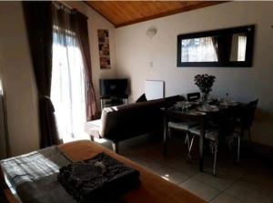 a living room with a couch and a table with a dining room at de Klerens Gems Topaz Self Catering Studio in Clarens