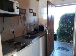 a kitchen with a sink and a microwave at de Klerens Gems Topaz Self Catering Studio in Clarens +4 photos