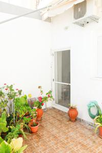 eine Terrasse mit Topfpflanzen und einem Fenster in der Unterkunft Traditional House in Laerma in Láerma