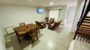a dining room with a wooden table and chairs at Duplex Sarmiento in Olavarría