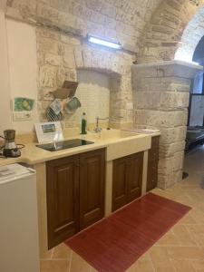 - une cuisine avec un évier et un mur en pierre dans l'établissement La Minicasa al Lago del Turano, à Castel di Tora