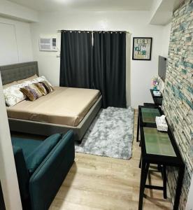 Gravins616 Condo BCD في باكولود: غرفة نوم بسرير واريكة وطاولة