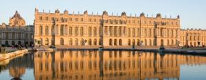 a large building with its reflection in the water at HOME VERSAILLES in Versailles