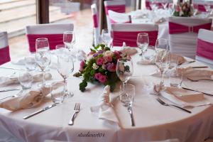 a white table with glasses and a bouquet of flowers at Agriturismo il Casale in Ponte Galeria