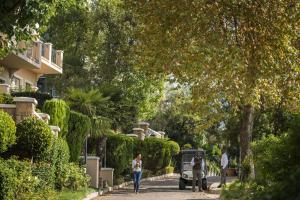 a group of people walking down a street with trees at Four Seasons Hotel The Westcliff in Johannesburg