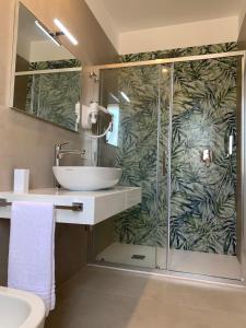 a bathroom with a glass shower and a sink at Coral Sand bed and breakfast in San Vito lo Capo